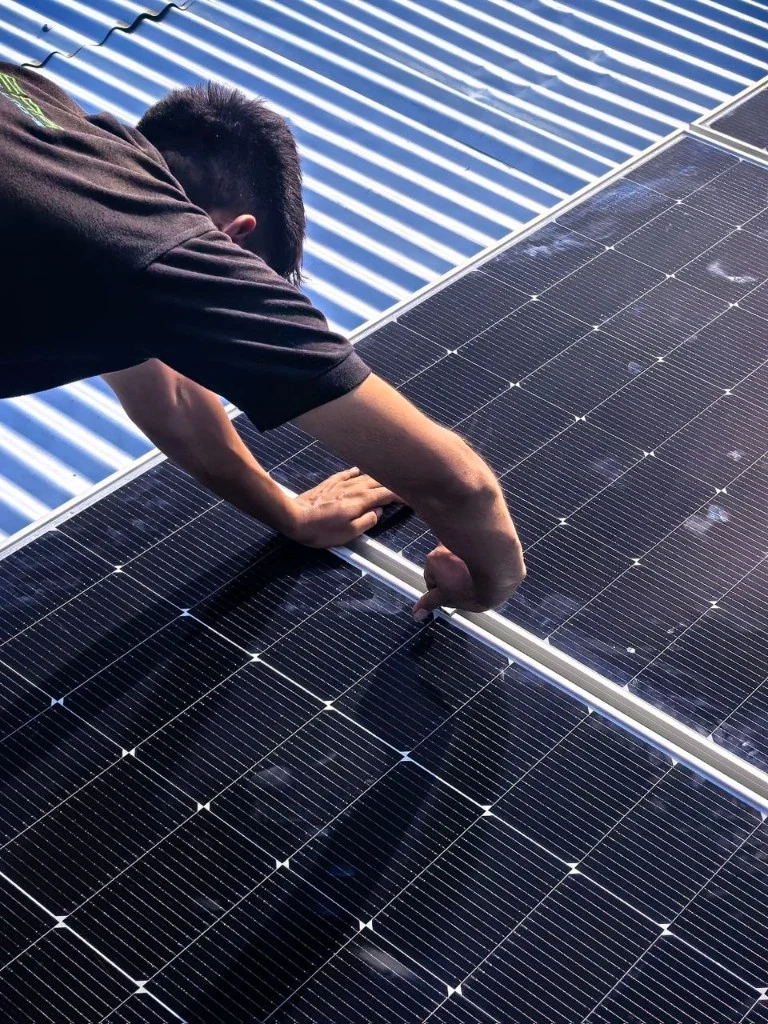 Técnico instalando un panel solar sobre cubierta metálica